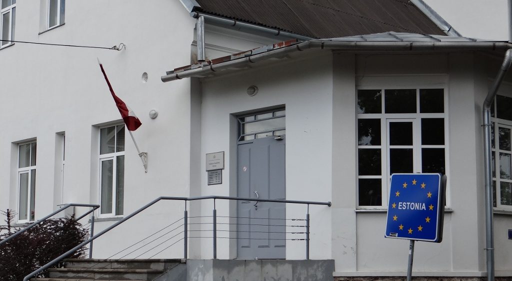 Estonia EU sign next to a building flying the Latvian flag