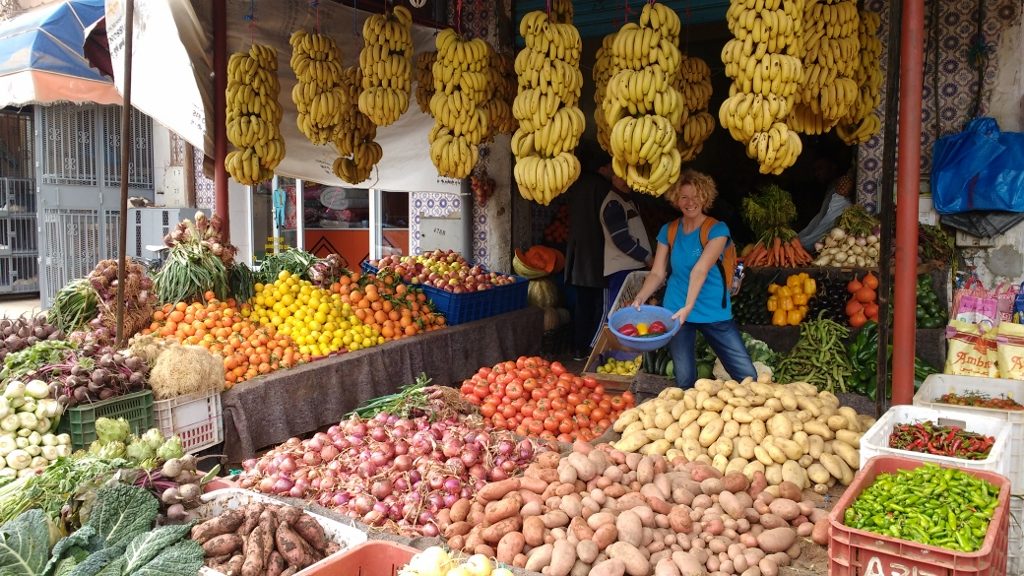 Jules buying fruit from a colourful stall in Tiznit