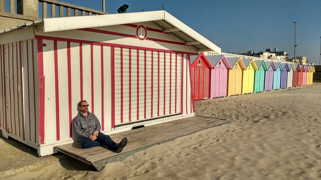 Sitting by brightly painted beach huts at Stella Plage in France