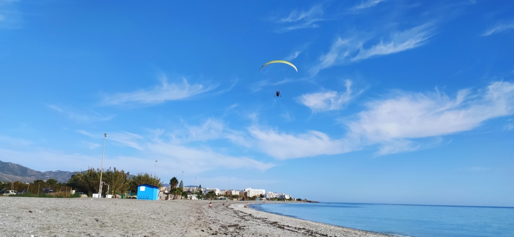 A powered paraglider breaking the silence above Playa Playazo