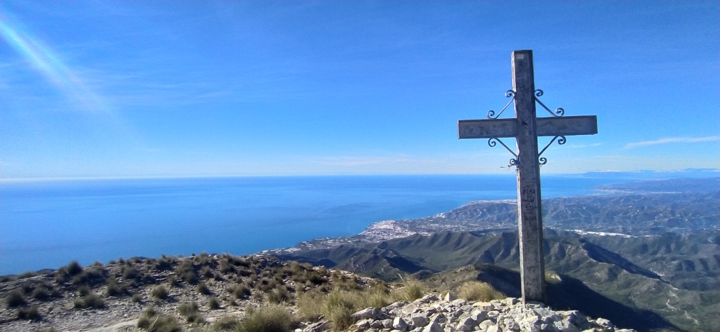 The cross on El Cielo, African mountains visible across the blue sea