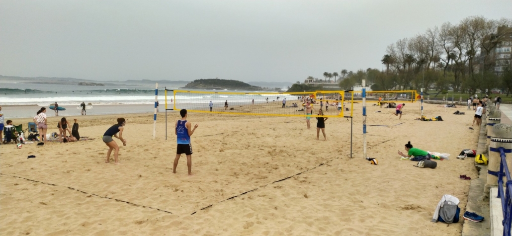 Beach volleyball courts and (in the background) lots of surfers in Santander in March 2021