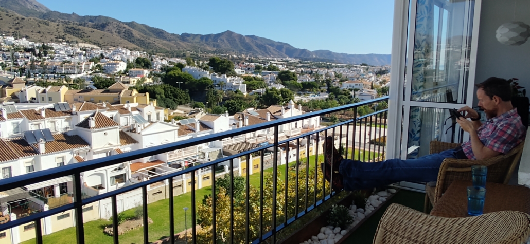 Squinting at my phone on the balcony of our AirBnB apartment in Nerja