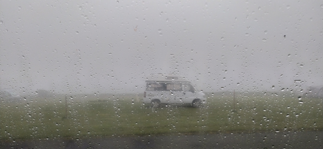 Campervan through a rainy window steamed up foggy.