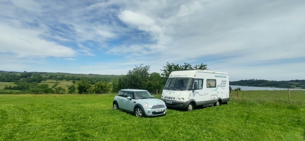 car and motorhome in field
