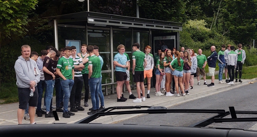 Hurling supporters off to the big match waiting at the bus stop