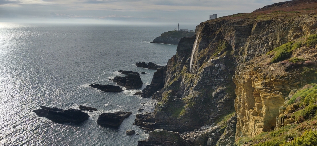 View from the cliff path of a waterfall, Ellis Tower RSPB view tower and South Stack Lighthouse 