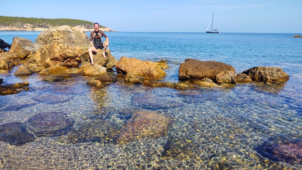 Snorkeler sitting on rocks in Ibiza