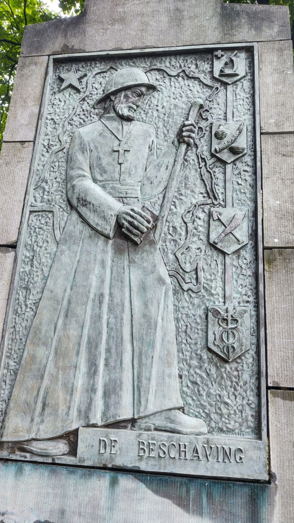 From the Leopold statue in Hasselt. On the left panel, with the subtitle: “DE BESCHAVING” [Civilization], a missionary is depicted with the map of Congo in the background. To its right are four more coats of arms with the following symbols from bottom to top:
• the staff of the herald Mercury and the cogwheel, symbolizing commerce and industry;
• the machete and the shovel, which represent agriculture;
• pottery, an ivory tooth and a basket, indicating craftsmanship;
• the red cross and a microscope, symbolizing hygiene and the fight against disease.