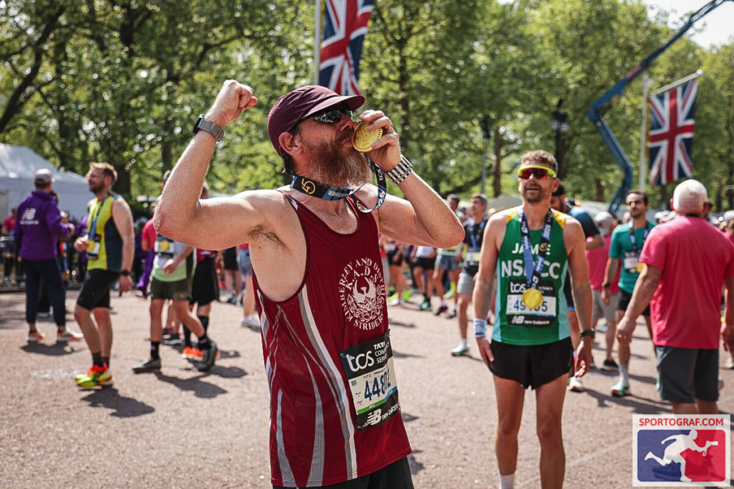 Jason kissing his medal at the finish of the London Marathon