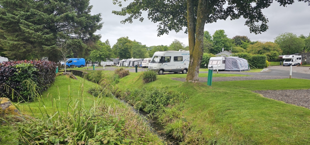 Motorhome parked up next to stream on a campsite