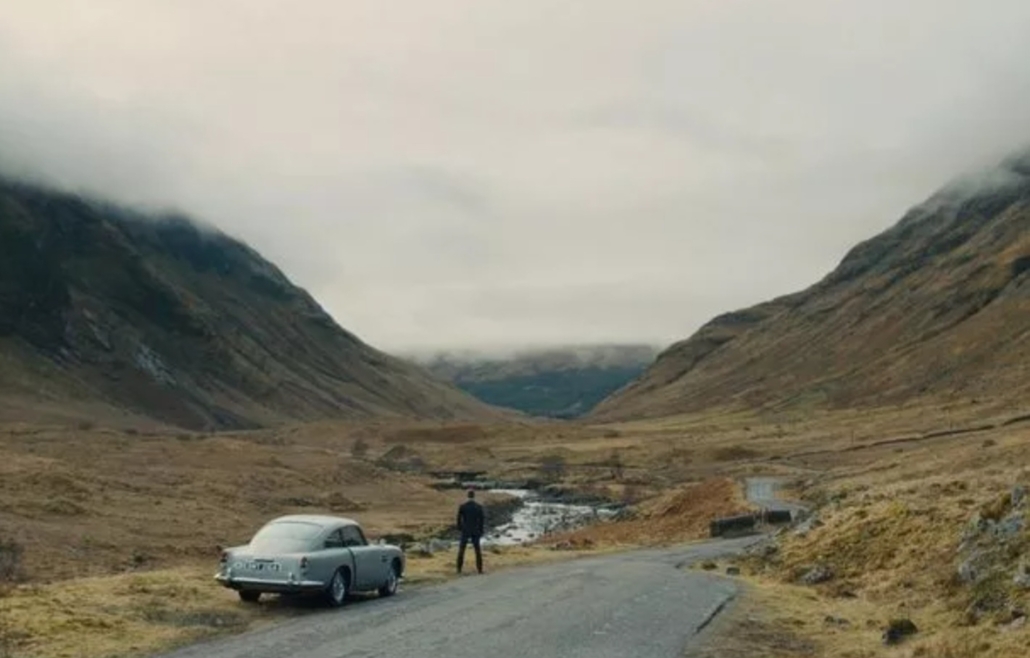 Scene from James Bond Skyfall film with Bond parked in laybe and looking out over mountain and valley