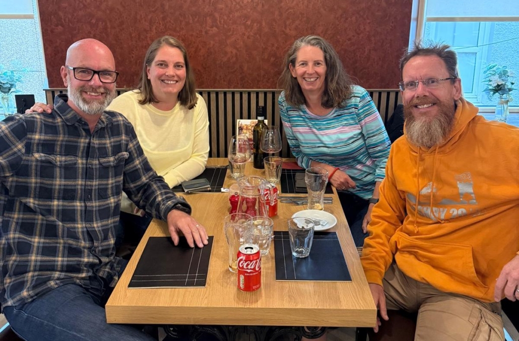 Four people sitting around a table in a restaurant