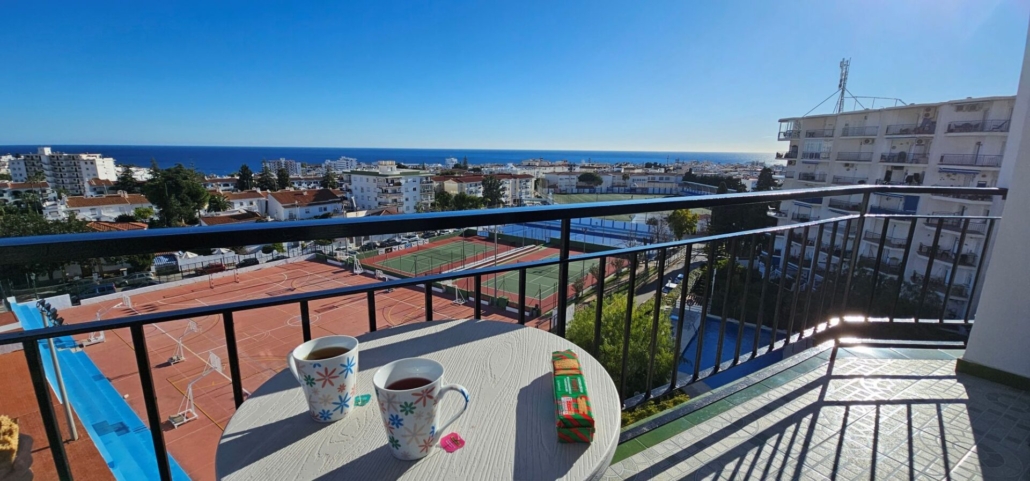 Balcony view of sports courts and sea in the distance